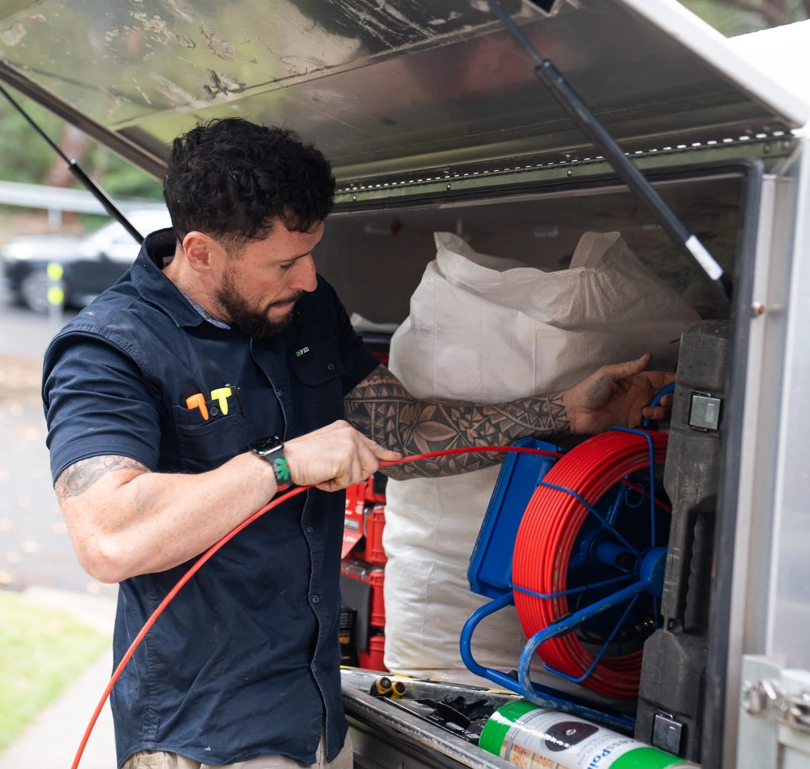 Tom Malone preparing a red hose reel at the open service vehicle