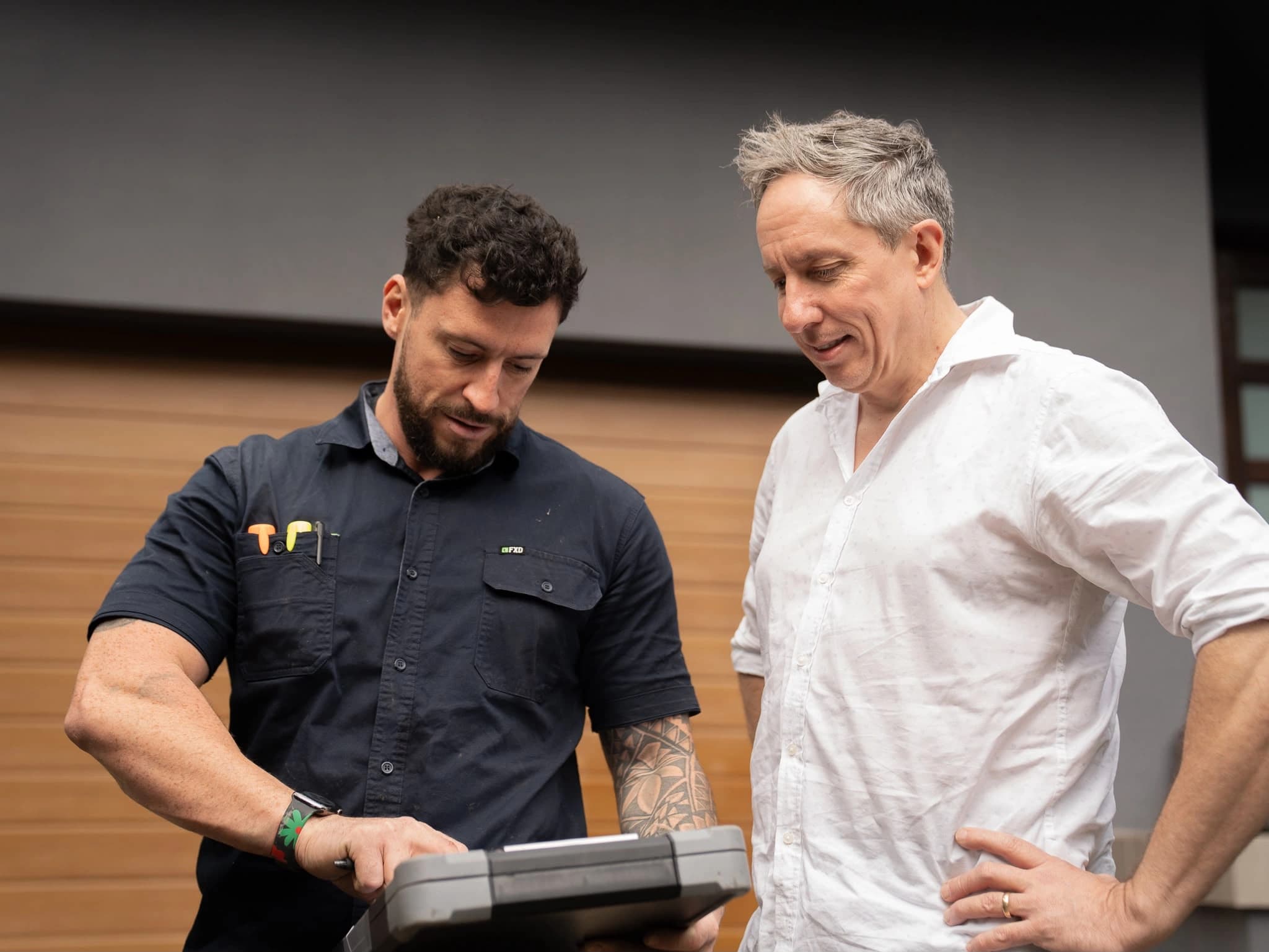 Tom Malone and a customer reviewing information on a tablet